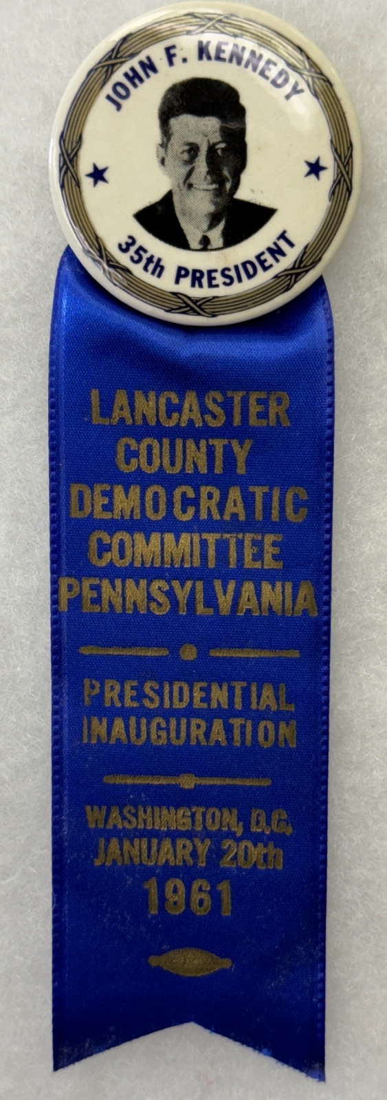 JOHN KENNEDY 1 3/4″ CELLO BUTTON & LANCASTER CO. PA INAUGURAL RIBBON-RARE & MINT